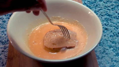 A person puts slice of bread in scrambled eggs. Vidéo 209948097