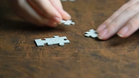 A person puts together different pieces of the puzzle. Stock Footage 143596598