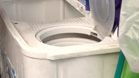 A person is putting clothes in a washing machine Stock Footage 289316254