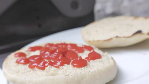 Person putting ketchup on bread Stock Footage 246699669