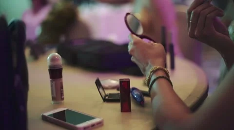 Person putting make-up on with a compact mirror in hand Stock Footage 47080398