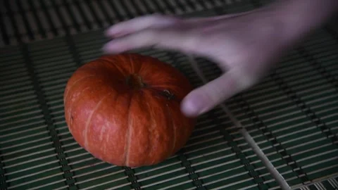 Person putting pumpkin on table Video stock 259367755