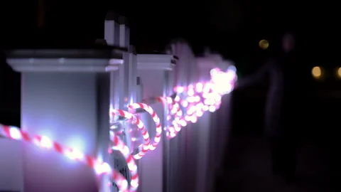 Person reaching out and touching colorful string lights during the night. Close Stock Footage 330985126