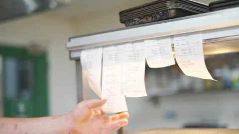 A person is reaching for a stack of receipts on a counter Stock Footage 301517358