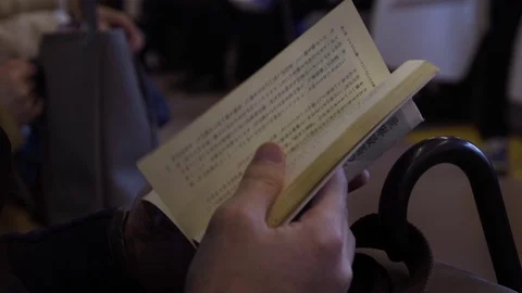 Person reading bible book while travelling in train Stock Footage 79444205