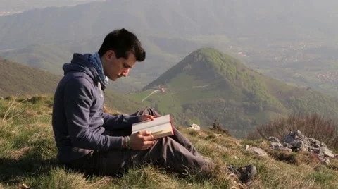 Person reading a book alone in front with a spectacular view Stock Footage 49595494