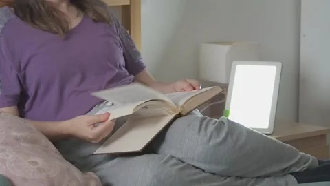 Person reading a book with a light therapy lamp, wellness and relaxing time Stock Footage 222000748