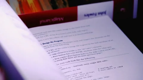 Person Reading through a programming book "Automate the boring stuff with Stock Footage 233120419