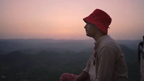 Person in Red Hat Watching Sunset Over Mountains Stock Footage 342224222
