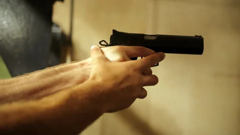 Person reloading a pistol with hands close-up at shooting range Stock Footage 286711023