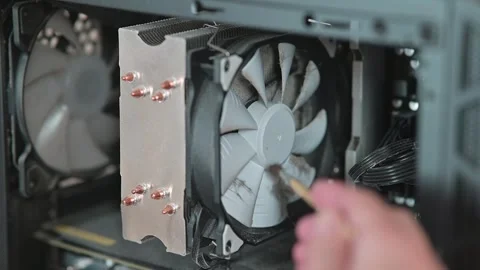 Person removes dust from a computer CPU cooler using a soft brush. Close-up of 스톡 동영상 337112636