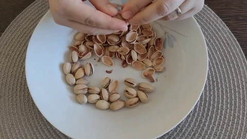 A person removes the shell from a pistachio Stock Footage 221421005