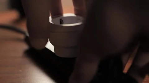 Person removing white smart plug adapter from black power strip on wooden f.. Stock-Footage 337682319