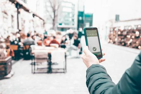 Person at the resturant using mobile app in phone to show immunization certif 스톡 사진