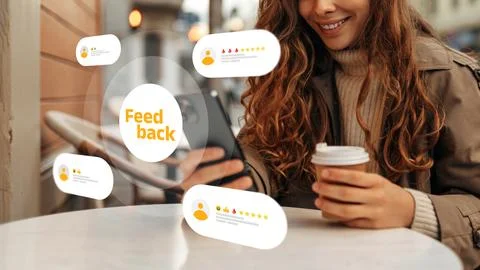 Person reviewing feedback on a device while sitting at a table in a cafe Stock Photos