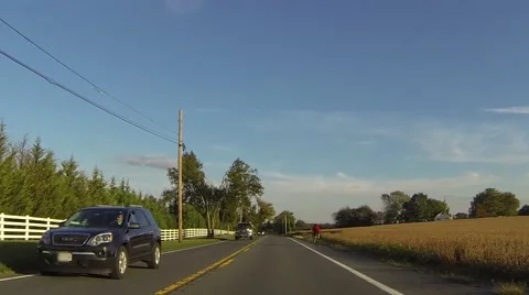 Person Riding Bicycle Down Rural Farm Road Stock Footage 59339472