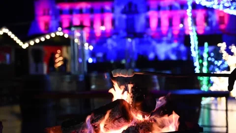 Person roasting marshmallows over burning bonfire at magical christmas mark.. Stockbeeldmateriaal 335183356