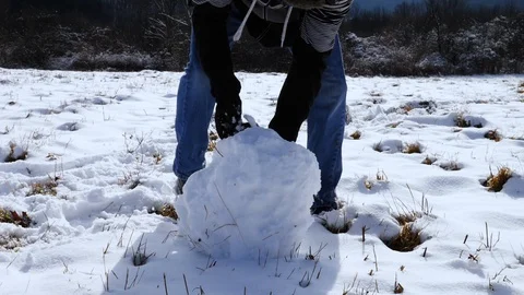 Person Rolling Large Snowball in Slow Motion Stock Footage 101214929
