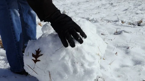 Person Rolling Large Snowball in Snow Covered Yard Stock Footage 101214878
