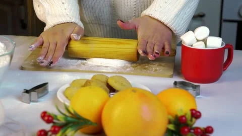 A person is rolling out dough with a rolling pin to bake Christmas cookies Stock Footage 319824431