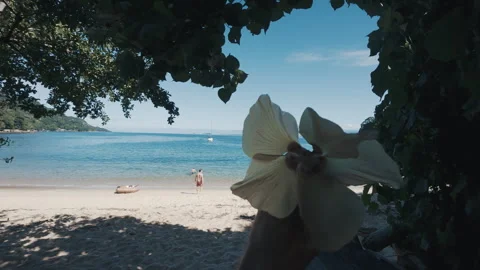 Person rotates flower in the head with sandy sunny beach on the background Stock Footage 339017446