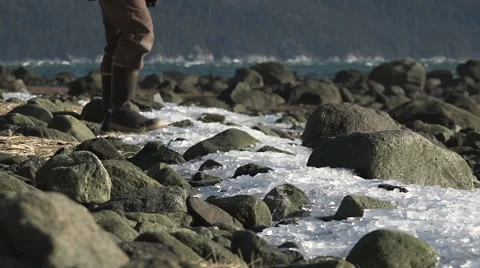 Person In Rubber Boots Walking Over Rough Icy Terrain Stock Footage
