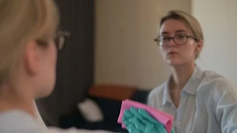 A person in rubber gloves uses a sponge to clean a flat surface in a well-lit Stock-Footage 337555887