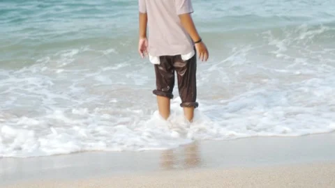 Person running barefoot through shallow ocean waves Stock Footage 337990975