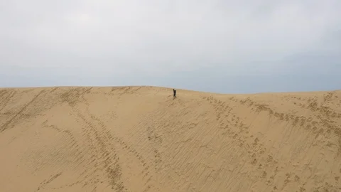 Person running fast down sand dune, aerial perspective Stock Footage 102508287