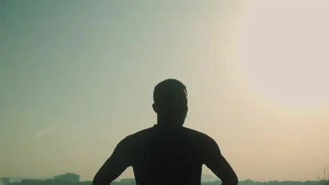 A person running in sunset silhouette Stock Footage