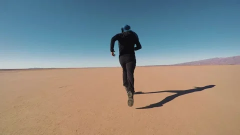 A person runs on a flat desert Stock Footage 243572707