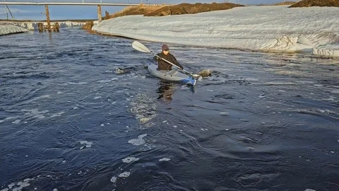 Person sails between ice pieces drifting along river Stock Footage 123695423