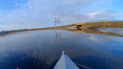 Person sails in canoe on river reflecting bank on sunny day Stock Footage 124456100