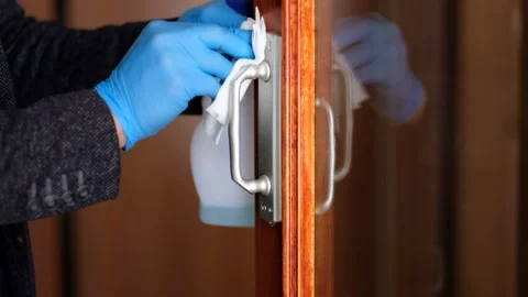 A person sanitizing a door handle Stock Footage 241742207