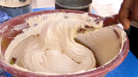 Person scooping mixed cake flour into cake pan for baking Stock Footage 229377232