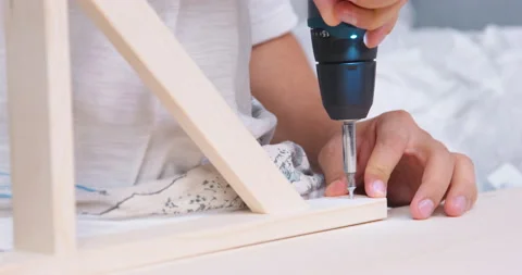 Person screws self-tapping screw into board with electric screwdriver. Stock Footage 217854676