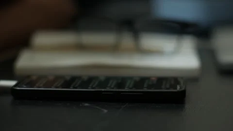 Person Scrolling on Smartphone at Desk Видео 345101813