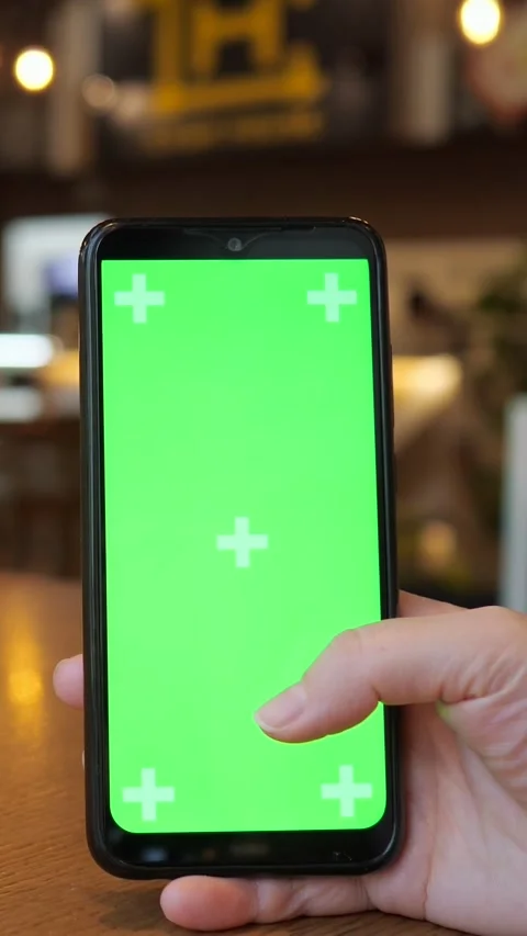 Person scrolling on a smartphone with a green screen display for chroma key Stock Footage 345459789