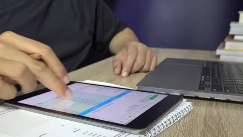 A person scrolling on a tablet screen with fingers in an office. Stock Footage 296794348