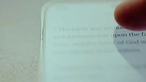 Person scrolling the text of Genesis 1 book of Bible on mobile phone screen Stock Footage 326943418
