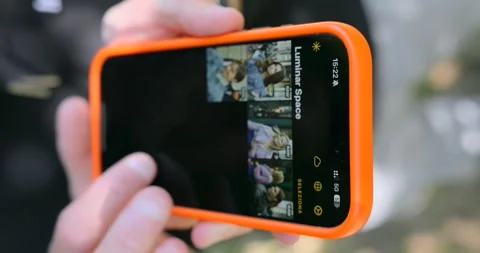 Person searching on Apple iPhone with Luminar app outdoors. Vertical format Stock Footage 337244575