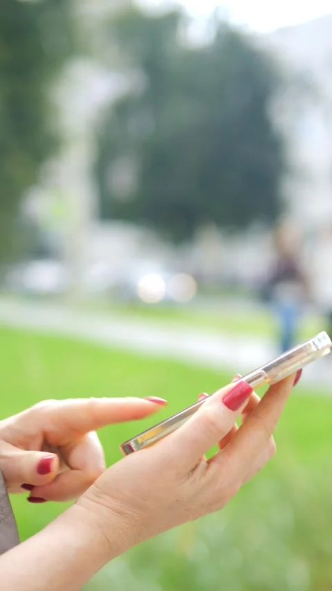 A person is seen actively texting on their smartphone while enjoying the urban Stock Footage 284914467