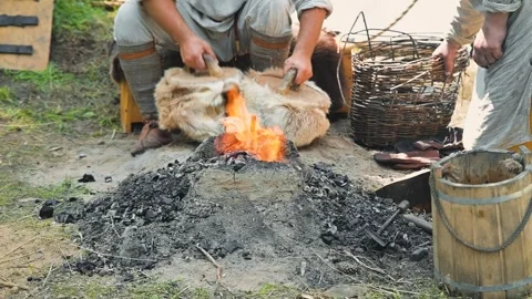 A person is seen preparing a fire using dry materials at an outdoor location. Stock Footage 345036688