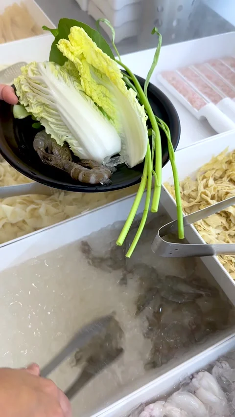 Person Selecting Fresh Raw Shrimp at a Shabu Shabu Buffet Stock Footage 334161692