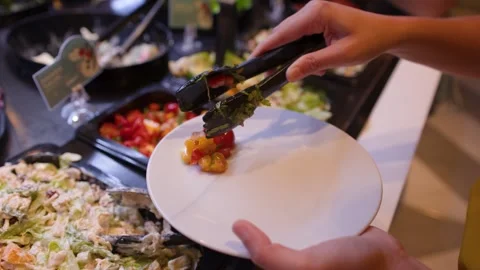 Person Serving Fresh Salad and Vegetables at a Restaurant Buffet Bar Stock Footage 336702806