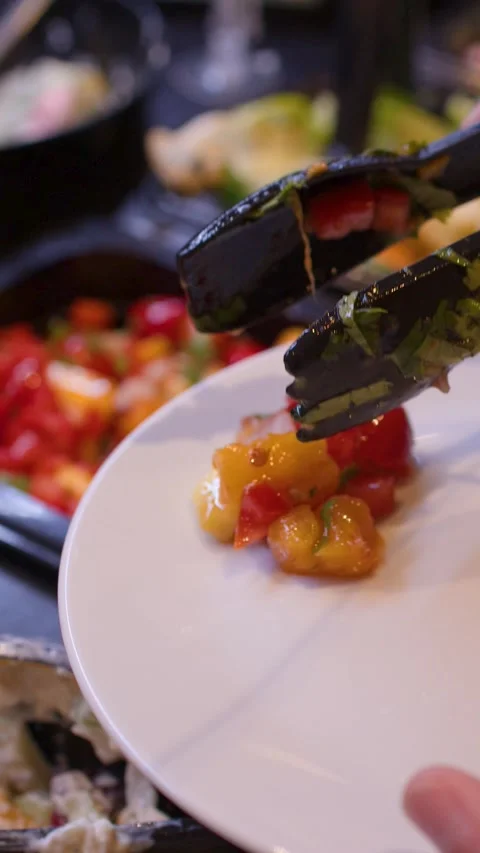 Person Serving Fresh Tomato and Pepper Salsa at a Restaurant Buffet Stock Footage 337224596