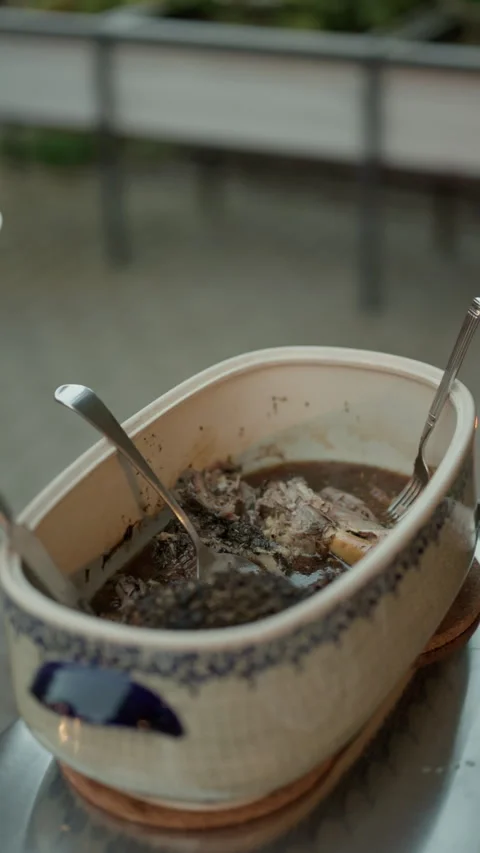 Person serving homemade stew from ceramic casserole into plate at dining table Stock Footage 345265235
