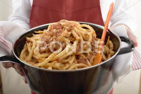 Person serving macaroni with mince sauce from pan Stock Photos