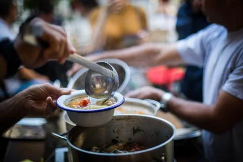 Person serving a portion of fish soup Stock Photos
