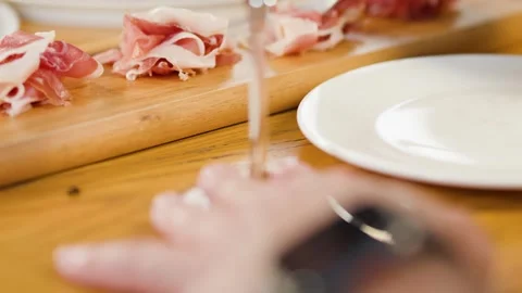 Person Serving Prosciutto Ham onto Plate at Italian Restaurant Dinner Stock Footage 339514862